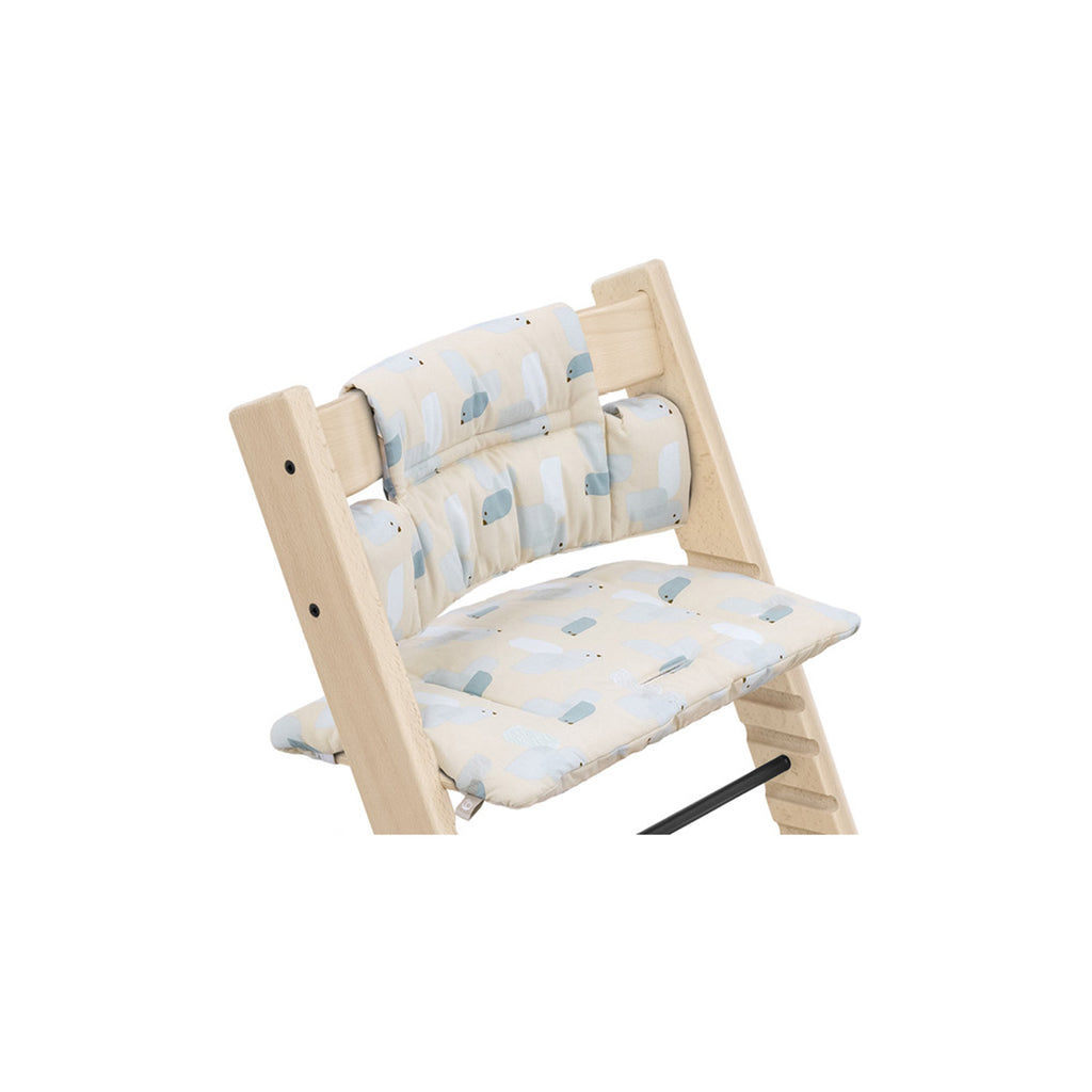 Wooden high chair features a removable cushion with a light blue and white bird pattern for comfortable and stylish seating. 

