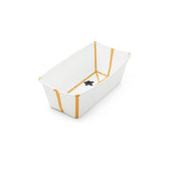 White baby bathtub with mustard yellow stripes and a black drain plug. 
